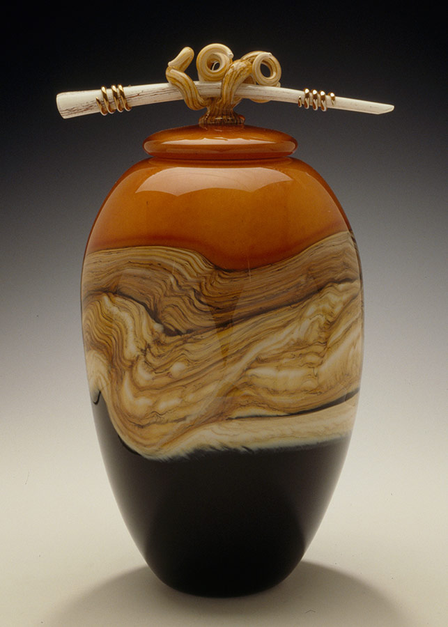 https://www.gartnerbladeglass.com/wp-content/uploads/2020/11/hand-blown-glass-tangerine-strata-covered-jar-bone-finial-gartner-blade-643x900-22.jpg